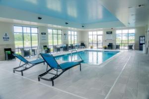 a pool with two chairs and a swimming pool at Hampton Inn By Hilton Huntley Chicago in Huntley