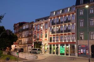 a group of buildings on a city street at night at Se Catedral Hotel Porto, Tapestry Collection By Hilton in Porto