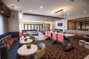 a hotel lobby with tables and couches and chairs at Hampton Inn By Hilton Huntley Chicago in Huntley