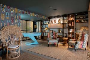 a living room with chairs and a table and shelves at Se Catedral Hotel Porto, Tapestry Collection By Hilton in Porto