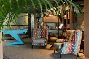 two chairs and a ping pong table in a room at Se Catedral Hotel Porto, Tapestry Collection By Hilton in Porto
