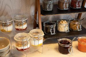 a shelf with jars of different types of desserts at Se Catedral Hotel Porto, Tapestry Collection By Hilton in Porto