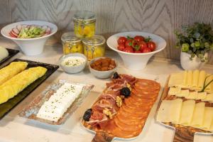 a table with different types of cheese and other foods at Se Catedral Hotel Porto, Tapestry Collection By Hilton in Porto