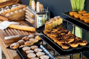 a display of different types of pastries and breads at Se Catedral Hotel Porto, Tapestry Collection By Hilton in Porto