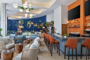 a lobby with a bar and chairs at Hilton Garden Inn Cancun Airport in Cancún