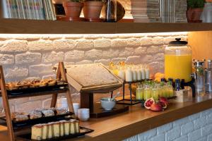 a buffet with pastries and drinks on a counter at Se Catedral Hotel Porto, Tapestry Collection By Hilton in Porto