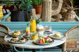 a table with plates of food and fruit on it at Se Catedral Hotel Porto, Tapestry Collection By Hilton in Porto