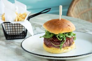 a sandwich on a plate on a table with fries at Se Catedral Hotel Porto, Tapestry Collection By Hilton in Porto