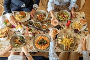 a group of people sitting around a table eating food at Se Catedral Hotel Porto, Tapestry Collection By Hilton in Porto