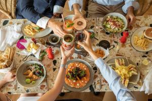 a group of people sitting around a table eating food at Se Catedral Hotel Porto, Tapestry Collection By Hilton in Porto