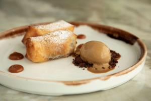 a plate with a piece of pie and a scoop of ice cream at Se Catedral Hotel Porto, Tapestry Collection By Hilton in Porto