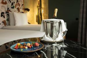 a bottle of champagne and a plate of food on a table at Se Catedral Hotel Porto, Tapestry Collection By Hilton in Porto