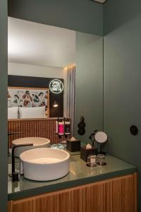 a bathroom with a sink and a large mirror at Se Catedral Hotel Porto, Tapestry Collection By Hilton in Porto