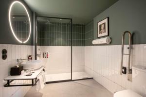 a bathroom with a shower and a sink and a mirror at Se Catedral Hotel Porto, Tapestry Collection By Hilton in Porto