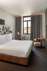 a hotel room with a large bed and a desk at Se Catedral Hotel Porto, Tapestry Collection By Hilton in Porto