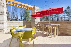 patio ze stołami, krzesłami i czerwonymi parasolami w obiekcie Home2 Suites By Hilton Richmond Short Pump w mieście Richmond
