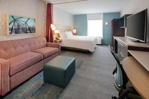 a hotel room with a couch and a bed at Home2 Suites By Hilton Richmond Short Pump in Richmond