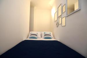 a small room with a bed with blue pillows at Medulić studio for 2 in old town with free parking in Šibenik