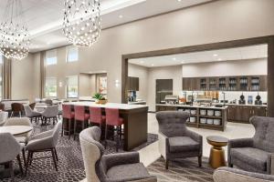 a lobby with a bar and chairs and a kitchen at Homewood Suites By Hilton Springfield Medical District in Springfield