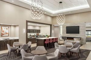 a lobby with chairs and a bar and a tv at Homewood Suites By Hilton Springfield Medical District in Springfield