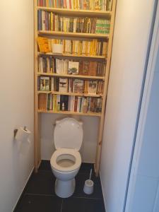 a bathroom with a toilet with a book shelf at Chez Frédéric in Saint Malo