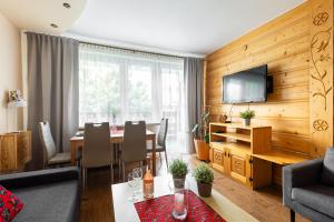 sala de estar con mesa de comedor y TV en Apartament Widok Zakopane en Zakopane