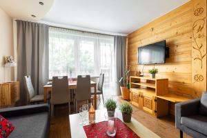 a living room with a dining table and a television at Apartament Widok Zakopane in Zakopane