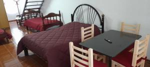 a bedroom with a table and a bed with a purple blanket at El Dormí Descanso! in Gualeguaychú