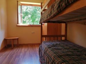 a bedroom with two bunk beds and a window at Apartamento con jardín Isard 1 in Pla de l'Ermita