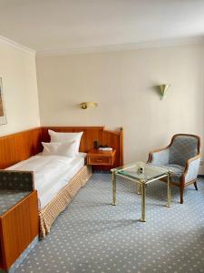 une chambre d'hôtel avec un lit, une chaise et une table dans l'établissement Antonappartements, à Dresde