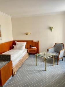 a hotel room with a bed and a chair and a table at Antonappartements in Dresden