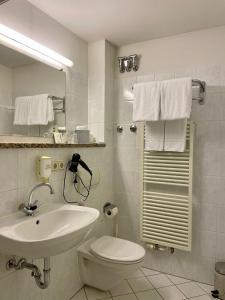 La salle de bains blanche est pourvue d'un lavabo et de toilettes. dans l'établissement Antonappartements, à Dresde