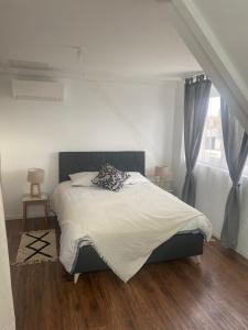 una camera da letto con un letto con lenzuola bianche e una finestra di CASA RAHMA a Amboise