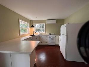 a kitchen with a white refrigerator and a sink at CAIA Lakeside Retreat - Sunken Lake in New Minas