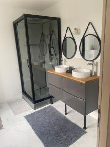 ein Badezimmer mit zwei Waschbecken und zwei Spiegeln in der Unterkunft CASA RAHMA in Amboise