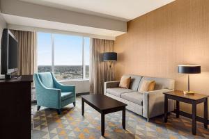 ein Wohnzimmer mit einem Sofa und einem Stuhl in der Unterkunft Doubletree By Hilton Pointe Claire Montreal Airport West in Pointe-Claire