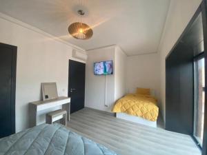 una camera con letto, scrivania e TV di New Luxury Duplex Apt Taghazout a Taghazout