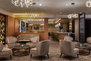 潘特克莱尔Doubletree By Hilton Pointe Claire Montreal Airport West的设有桌椅和酒吧的大厅