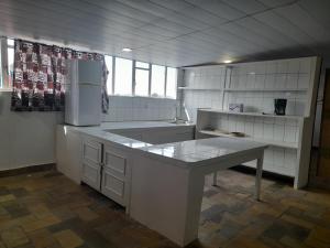 a kitchen with a counter and a refrigerator at Rwanda African Art Museum in Nyabisindu
