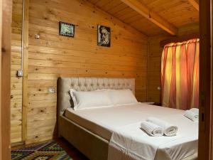 ein Schlafzimmer mit einem Bett in einer Holzhütte in der Unterkunft Uji i Panjes Llogara in Vlorë