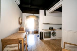 a kitchen with a table and a kitchen with a washing machine at K57 Old Town Apartment in Pécs