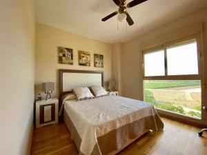 a bedroom with a bed and a ceiling fan at A&N Spacious Beach Apartment with Pool & Parking in Torre del Mar