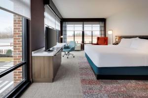 een hotelkamer met een bed en een flatscreen-tv bij Hilton Garden Inn Haymarket in Haymarket