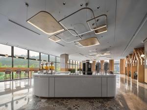 hol z recepcją i dużymi oknami w obiekcie Hilton Garden Inn Huzhou Anji Phoenix Mountain w mieście Anji