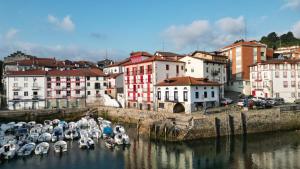 een groep boten is aangemeerd in een haven bij Apartamentos&Spa Mundaka Port in Mundaka