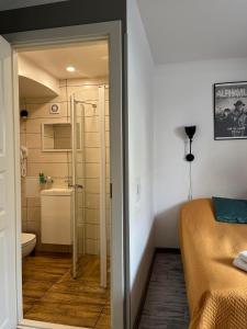 a small bathroom with a bed and a shower at Godart Rooms Guesthouse in Tallinn