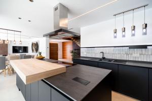 Una cocina con gabinetes negros y una encimera de madera. en ALBA SEA VILLA, en Chiclana de la Frontera