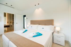 Un dormitorio con una cama blanca con toallas. en ALBA SEA VILLA, en Chiclana de la Frontera 17 fotos más