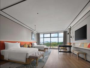 pokój hotelowy z łóżkiem i telewizorem w obiekcie Hilton Garden Inn Huzhou Anji Phoenix Mountain w mieście Anji