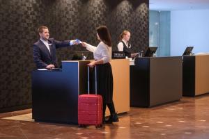 a man and a woman shaking hands in an office at DoubleTree by Hilton Hannover Schweizerhof in Hannover